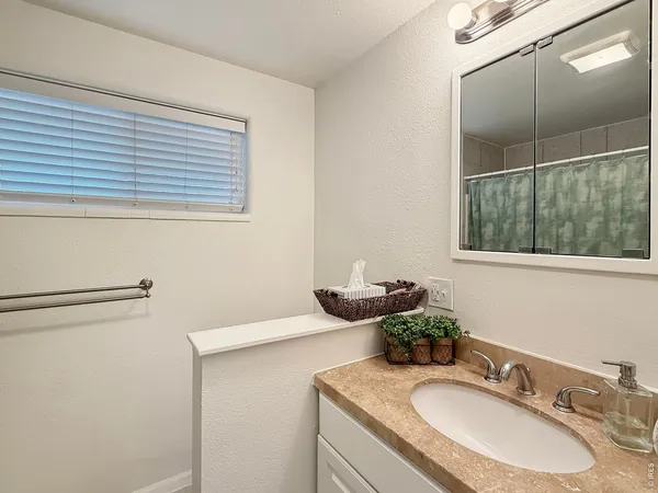 a bathroom with a granite countertop sink and a mirror