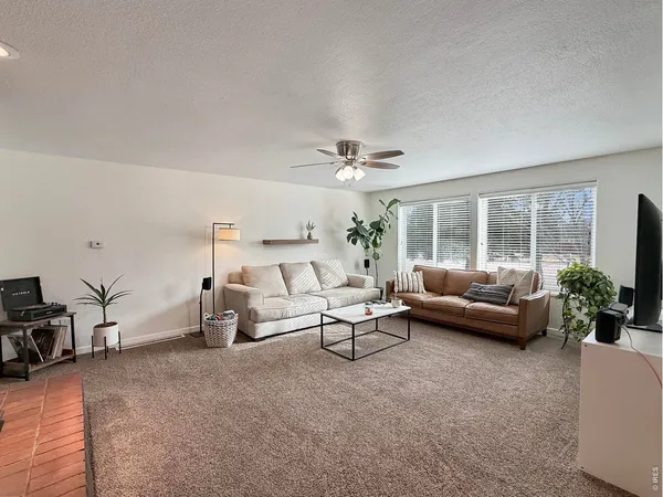 a living room with furniture and large windows