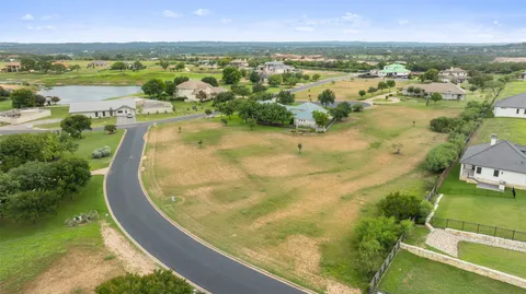 an aerial view of residential houses with outdoor space and trees