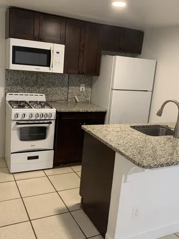 a kitchen with a stove a microwave and a refrigerator