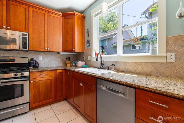 a kitchen with stainless steel appliances granite countertop a stove a microwave and a refrigerator