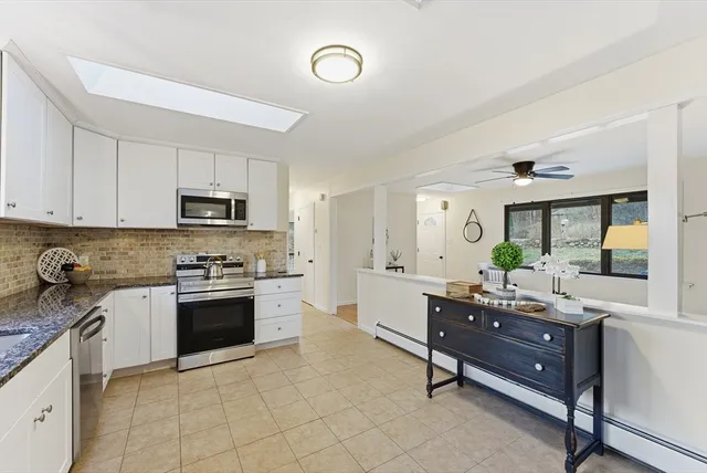 a kitchen with stainless steel appliances granite countertop a sink dishwasher stove top oven and cabinets