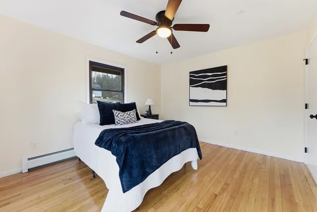 a bedroom with bed and wooden floor