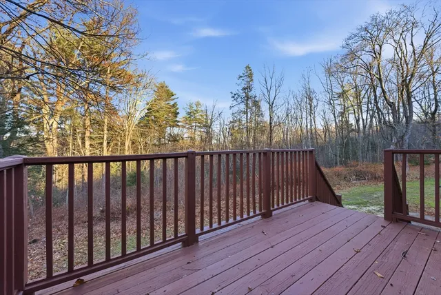 a balcony with wooden floor and trees in the back