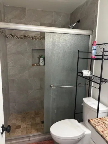 a bathroom with a toilet and a shower