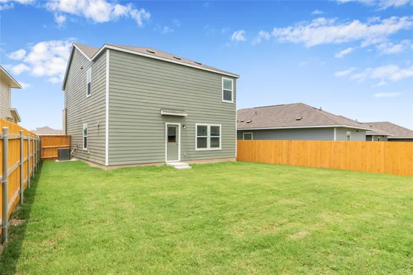 a view of a house with a backyard and a tub