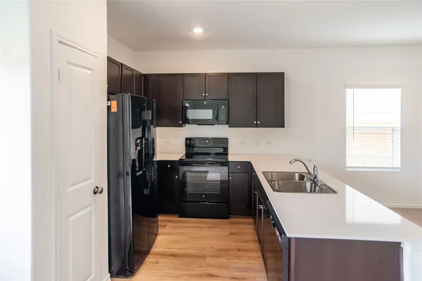 a kitchen with granite countertop a refrigerator stove and sink