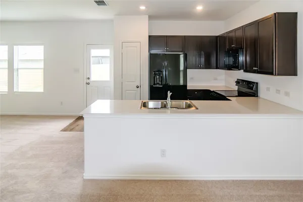 a kitchen with kitchen island a sink stainless steel appliances and cabinets