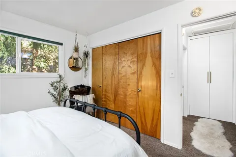 a bedroom with a bed a dresser and a window