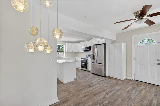 a view of empty room with wooden floor and ceiling fan