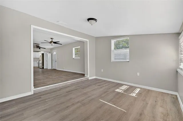 a view of a room with wooden floor and a ceiling fan