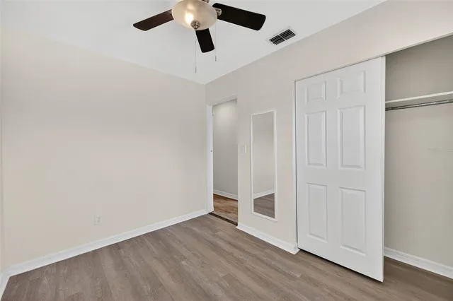 a view of a small space with wooden floor and a ceiling fan