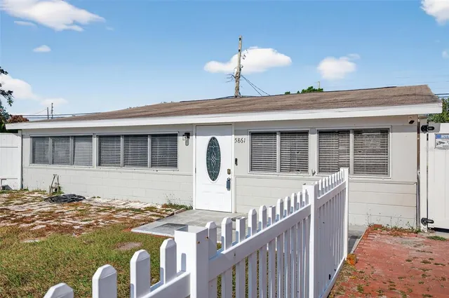 a kitchen with white cabinets and wooden floor
