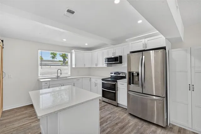 a kitchen with granite countertop a sink stove and refrigerator