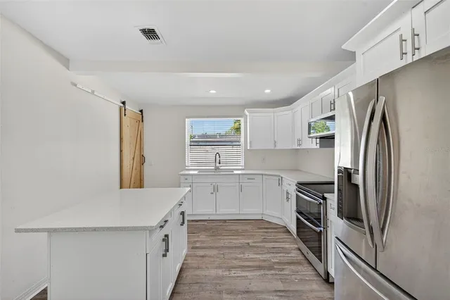 a kitchen with white cabinets and stainless steel appliances