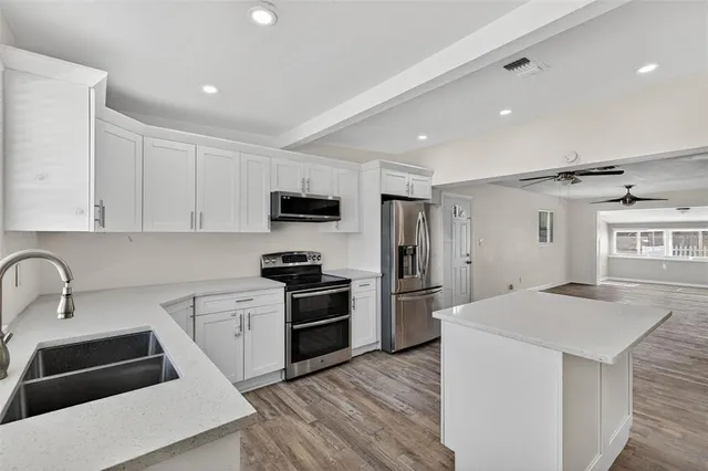 a kitchen with stainless steel appliances a refrigerator a stove microwave and cabinets