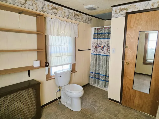 a bathroom with a toilet and a shower