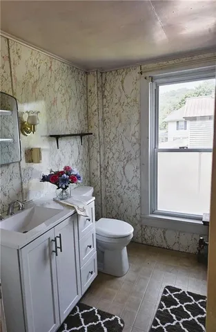 a bathroom with a sink toilet and window