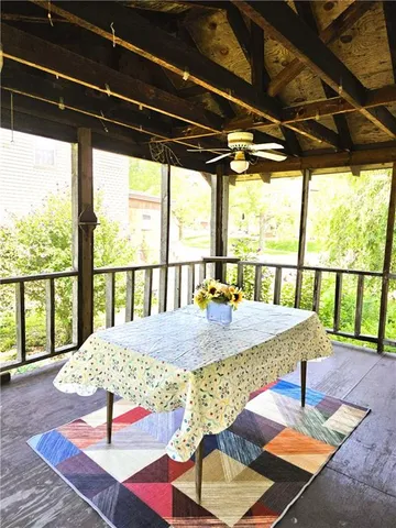 a view of a porch with furniture and wooden floor