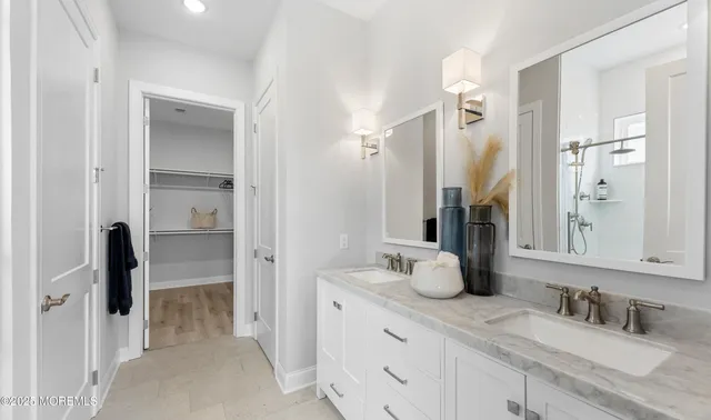 a bathroom with double vanity sink and two mirror