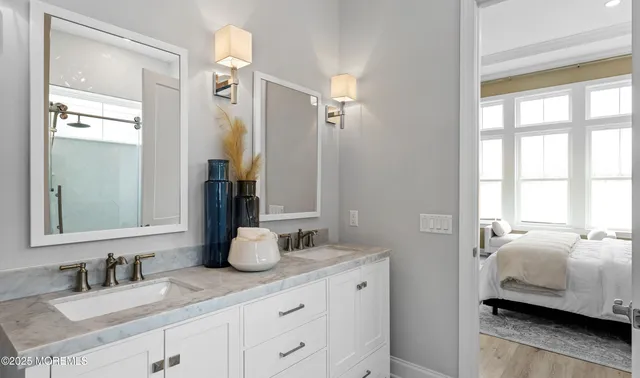 a en suite bathroom with a double vanity sink and a mirror