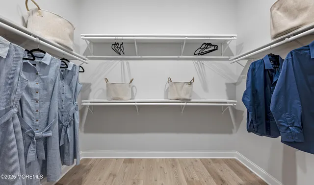 a view of walk in closet with clothes and shoes