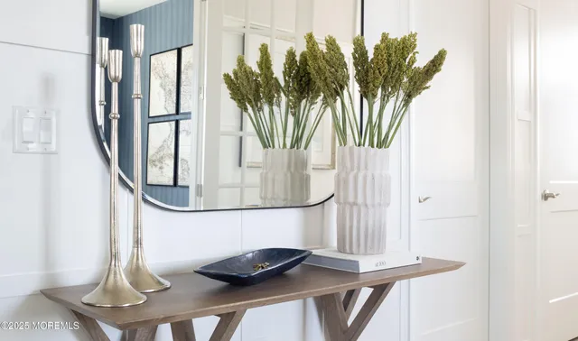 a vase of flowers sitting next to a wooden floor
