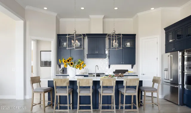 a kitchen with stainless steel appliances kitchen island granite countertop a table chairs and a refrigerator