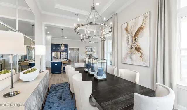 a view of a dining room with furniture a chandelier and wooden floor