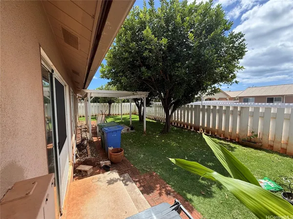 a view of backyard with a deck and a large tree