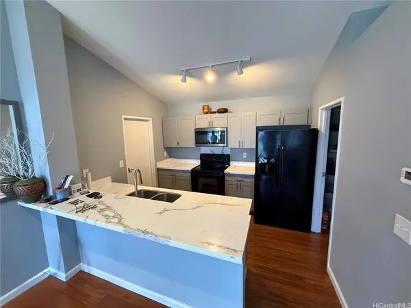 a kitchen with a refrigerator and a stove top oven