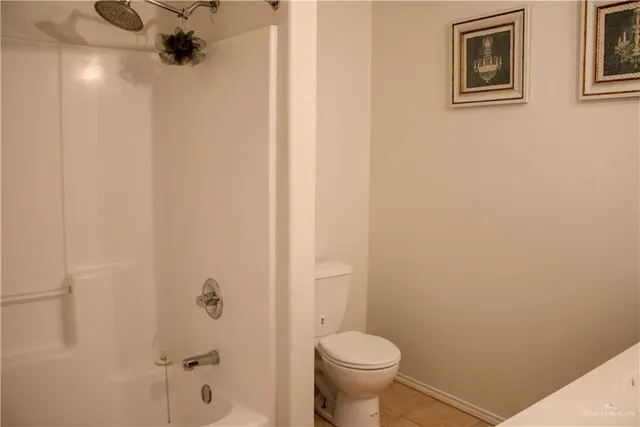a bathroom with a granite countertop sink and a toilet