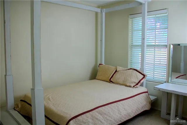 a bedroom with a bed and a flat tv screen on a dresser