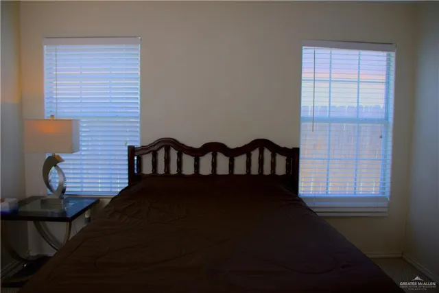 a black bed sitting in a bedroom next to a window