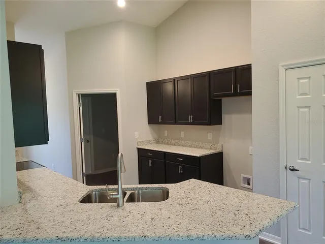 a kitchen with stainless steel appliances kitchen island granite countertop a refrigerator and a sink