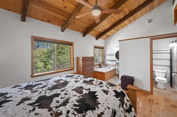 a bedroom with a bed dresser and a large window