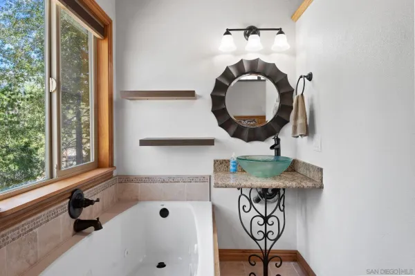 a bathroom with a sink a mirror and a window