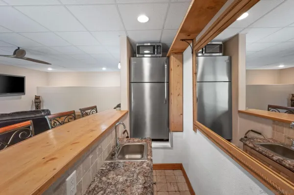 a kitchen with stainless steel appliances granite countertop a refrigerator a stove and a sink with wooden floor