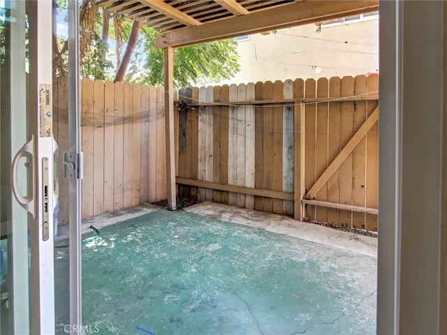 a view of a backyard with wooden fence and a large window