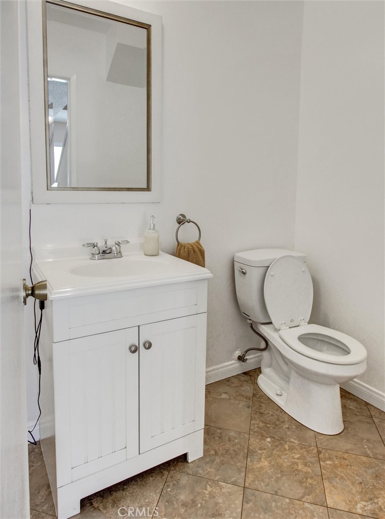 1881 Mitchell Avenue, Unit 63 Tustin, CA 92780 - Photo 12 of 24 a bathroom with a toilet sink and mirror