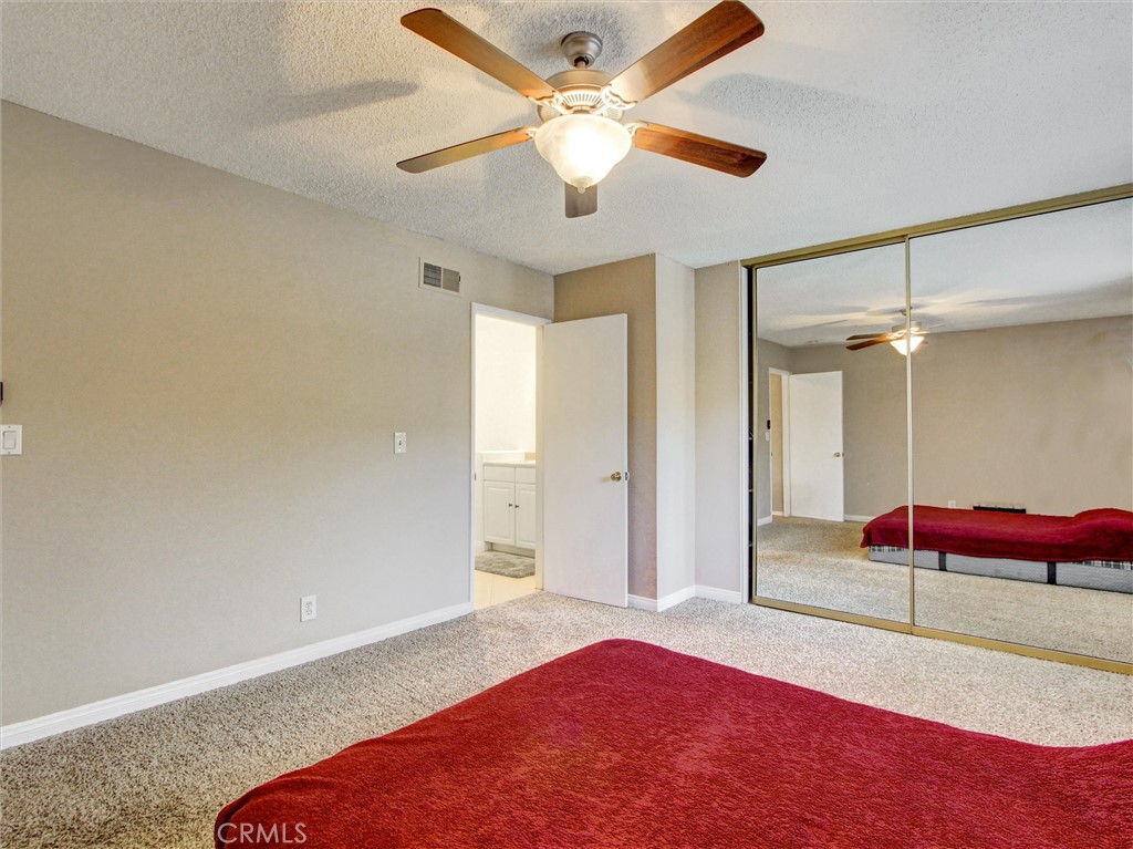 1881 Mitchell Avenue, Unit 63 Tustin, CA 92780 - Photo 15 of 24 a bedroom with a bed and a chandelier