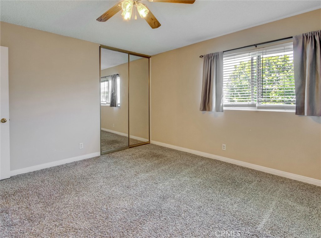 1881 Mitchell Avenue, Unit 63 Tustin, CA 92780 - Photo 19 of 24 an empty room with a chandelier fan and windows
