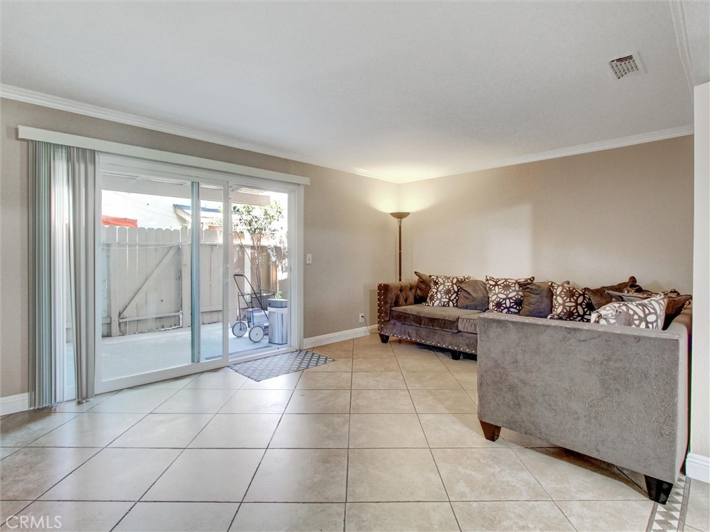 1881 Mitchell Avenue, Unit 63 Tustin, CA 92780 - Photo 10 of 24 a living room with furniture and a floor to ceiling window