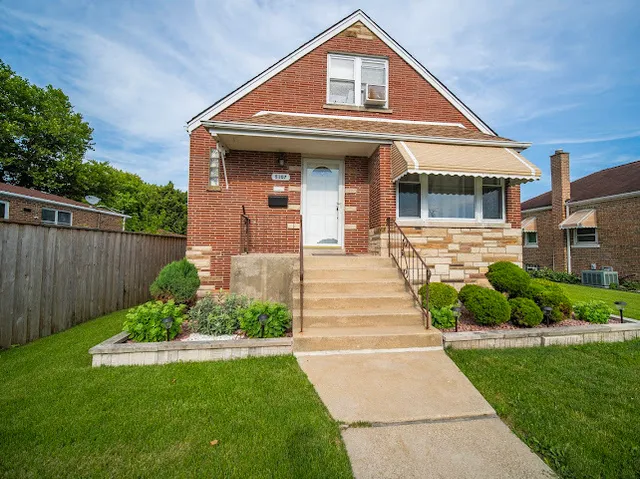 a front view of a house with a yard and potted plants