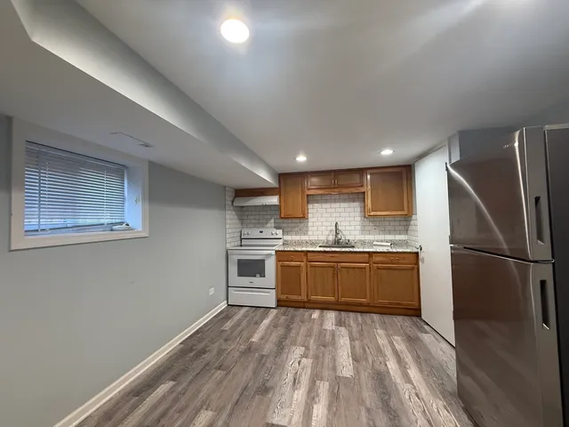 a kitchen with stainless steel appliances granite countertop a refrigerator sink and stove