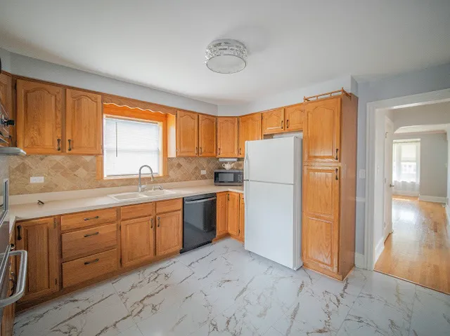 a kitchen with a refrigerator sink and cabinets