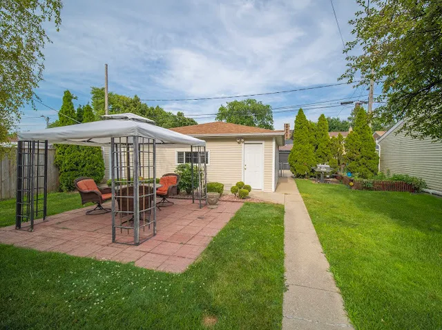 a view of a patio with a table and chairs under an umbrella