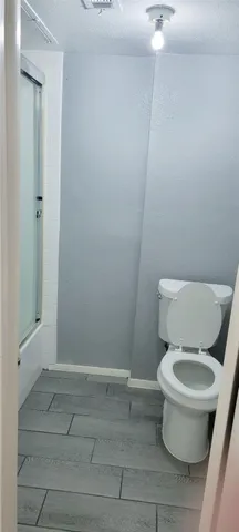 a white toilet sitting next to a shower