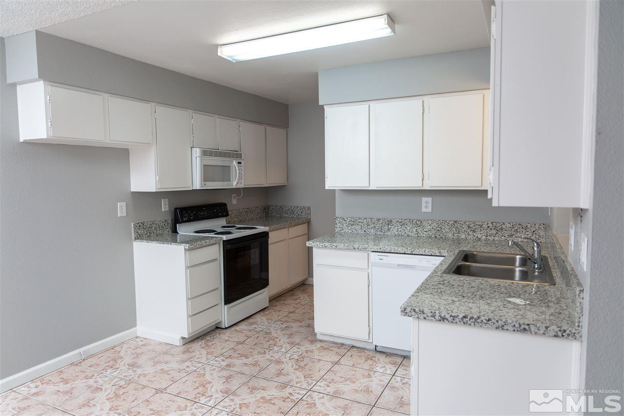 6545 Lotus Street Reno, NV 89506 - Photo 4 of 28 a kitchen with granite countertop a sink stove and cabinets
