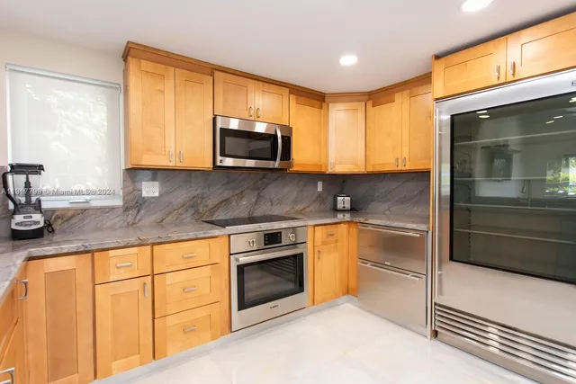 a kitchen with granite countertop a stove microwave and sink